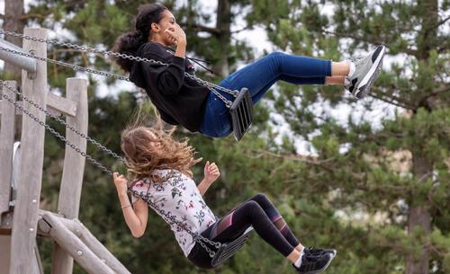 Playing on swings at Alconbury Weald