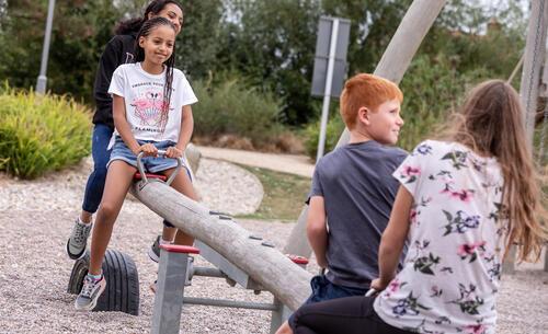 Children playing on a wooden see saw