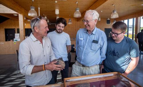 A group of men looking at a piece of archaeology