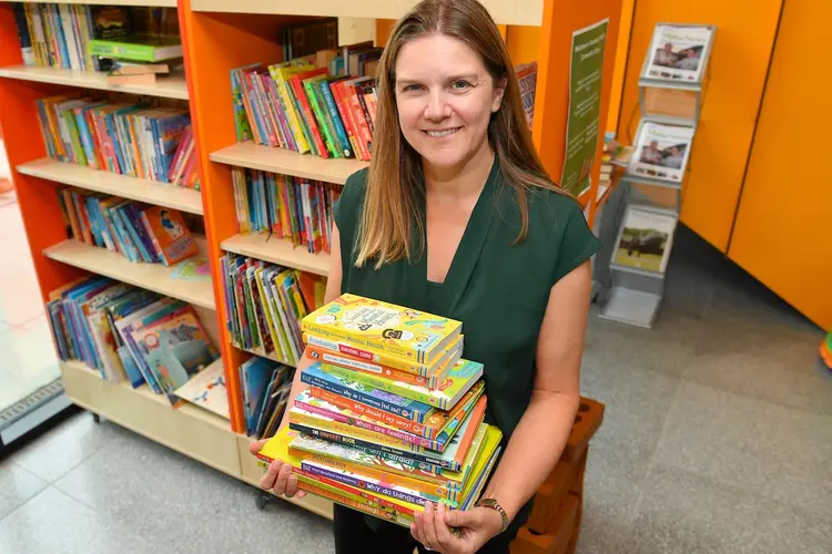 Natalie from Alconbury Weald Library holding some of the books from David Wilson Homes